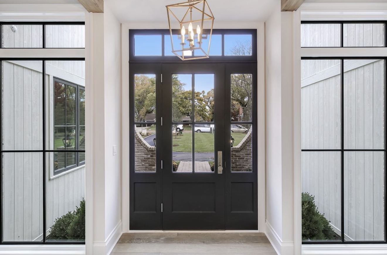 Tailored dark entry door framed by sidelights
